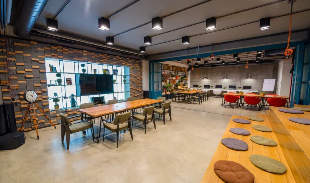 Pune office interior: open floor with planting, soft lighting, and mixed seating zones